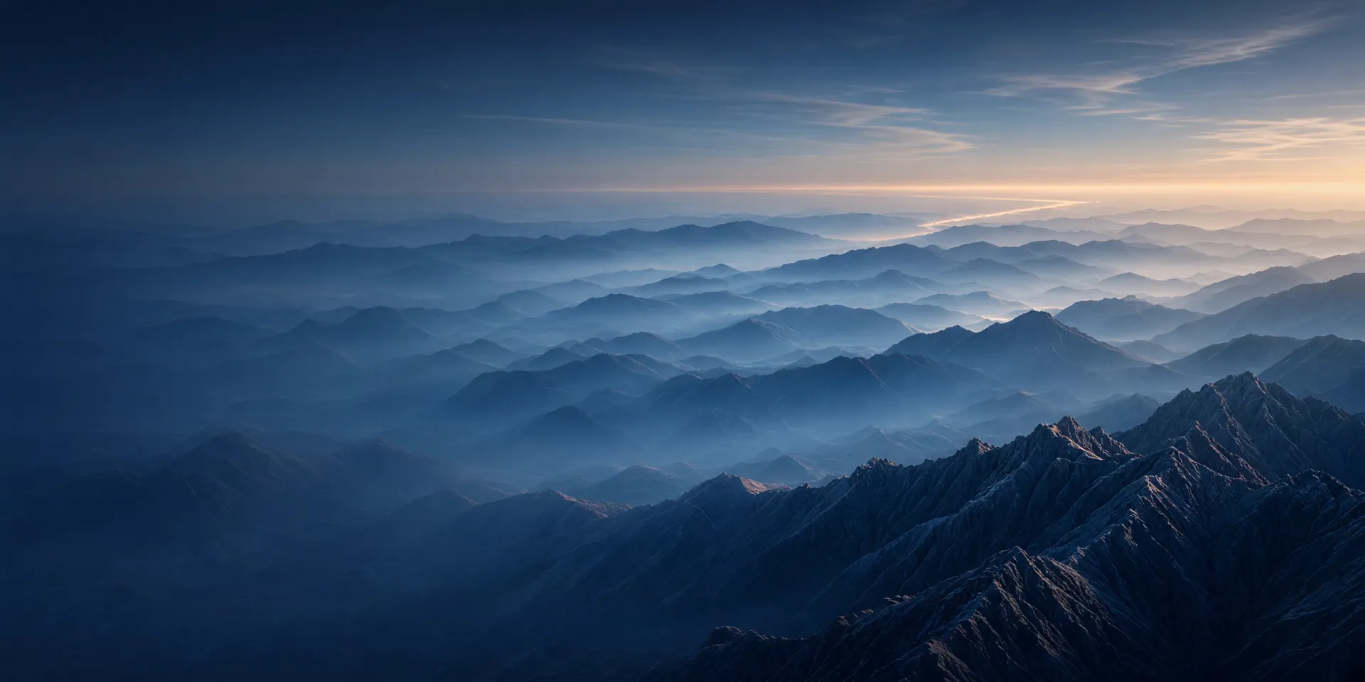 Layered blue mountain ridges receding into morning haze at dawn